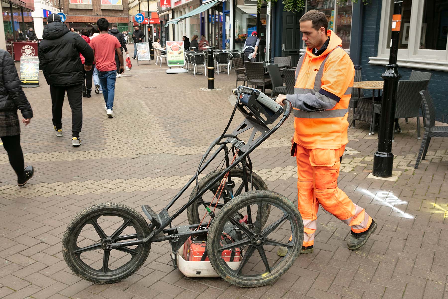 worker in hi vis using ground penetrating radar equipment