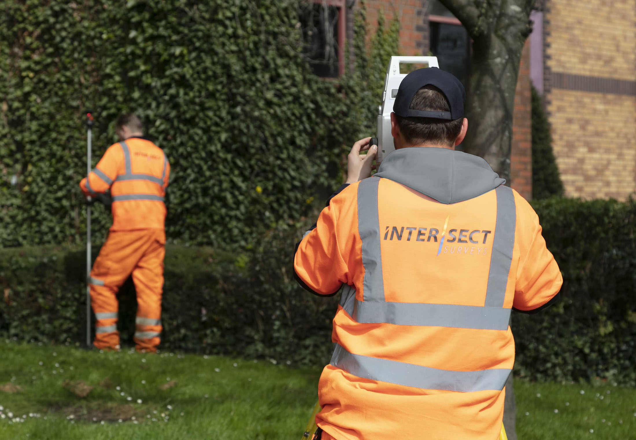 topographical survey with 2 workmen in orange jackets